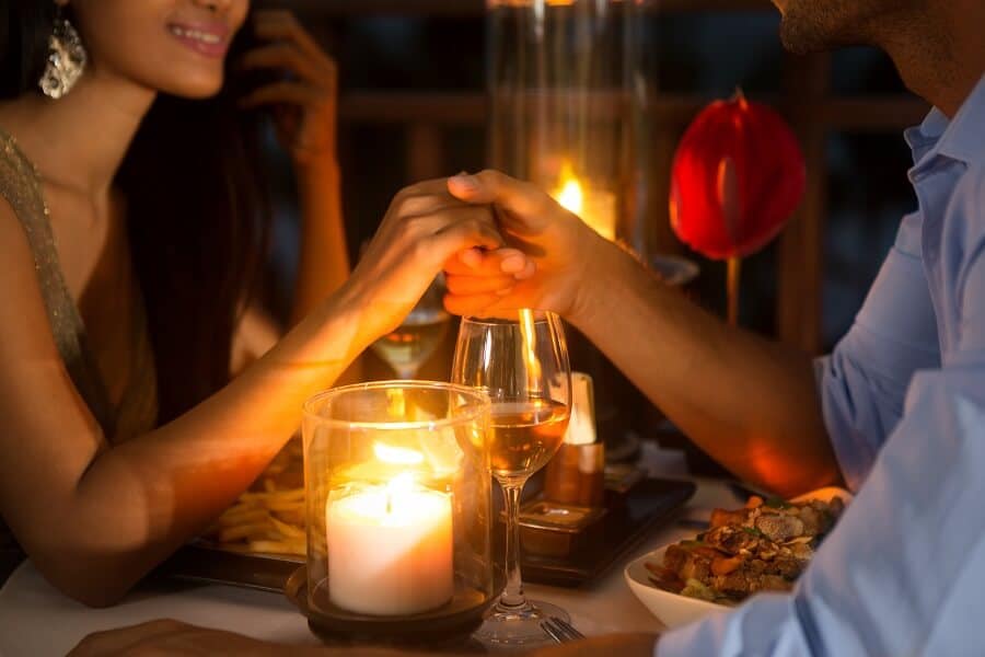 Una coppia tiene le mani a cena a lume di candela.