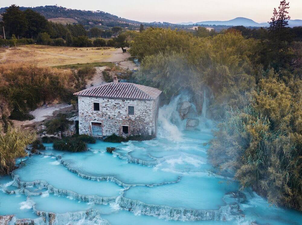 Cascate del Mulino in Toscana, con acqua turchese e natura circostante.