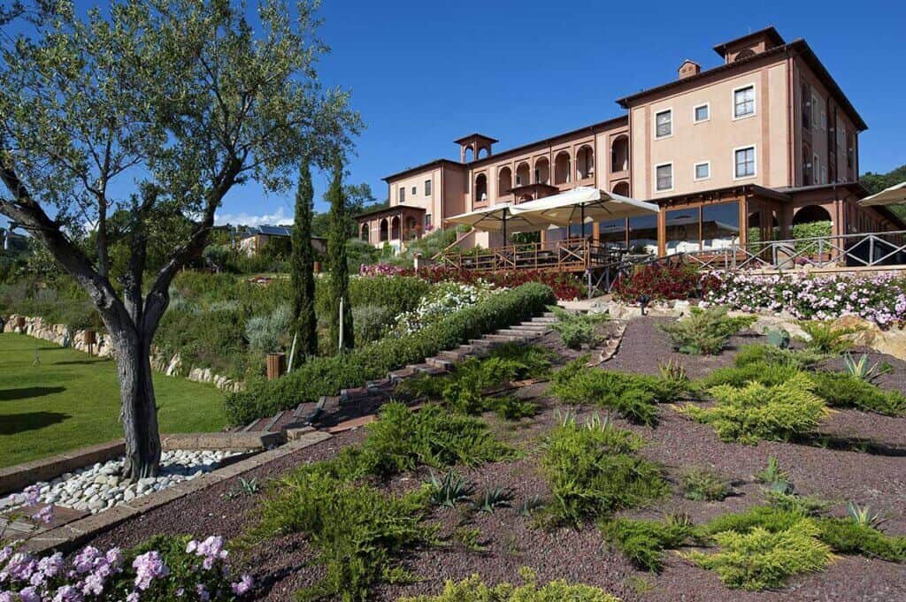 Edificio in stile villa con giardino paesaggistico su una collina soleggiata.